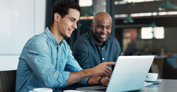 business colleagues discuss work on laptop