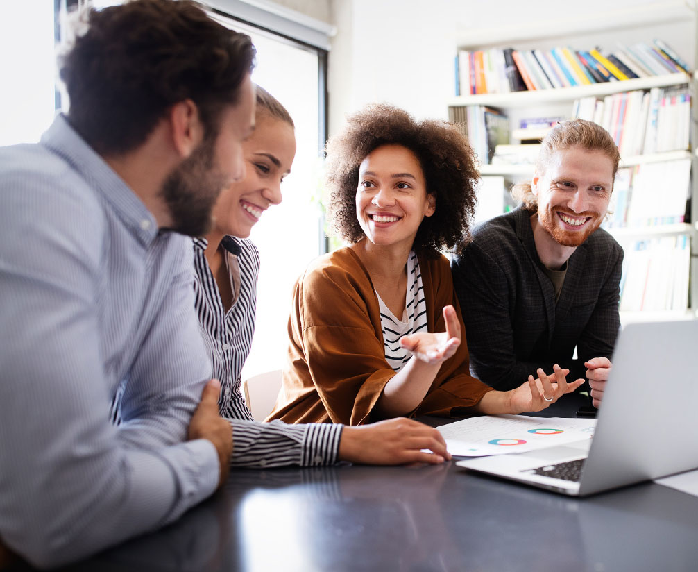 4 people looking at a laptop computer