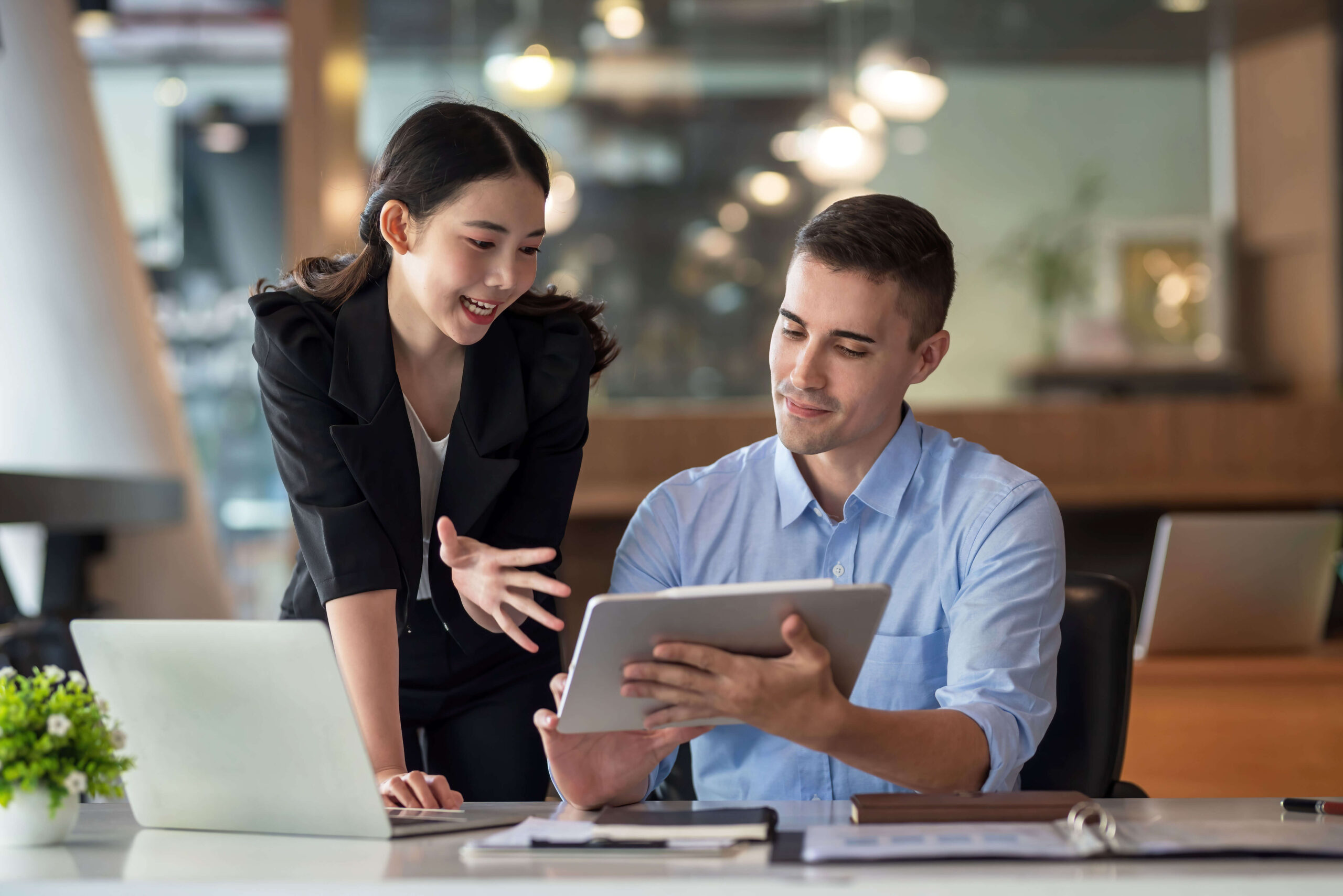 coworkers discuss work laptop tablet