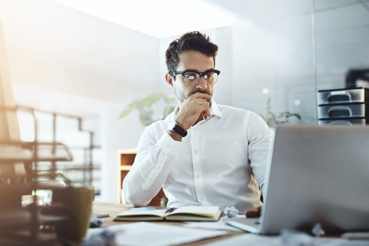 Professional man deep in thought looking at computer