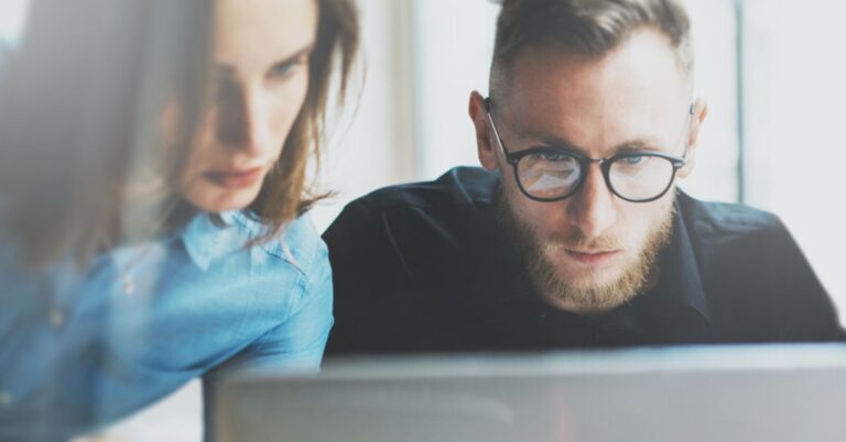 Woman and man staring into a computer screen