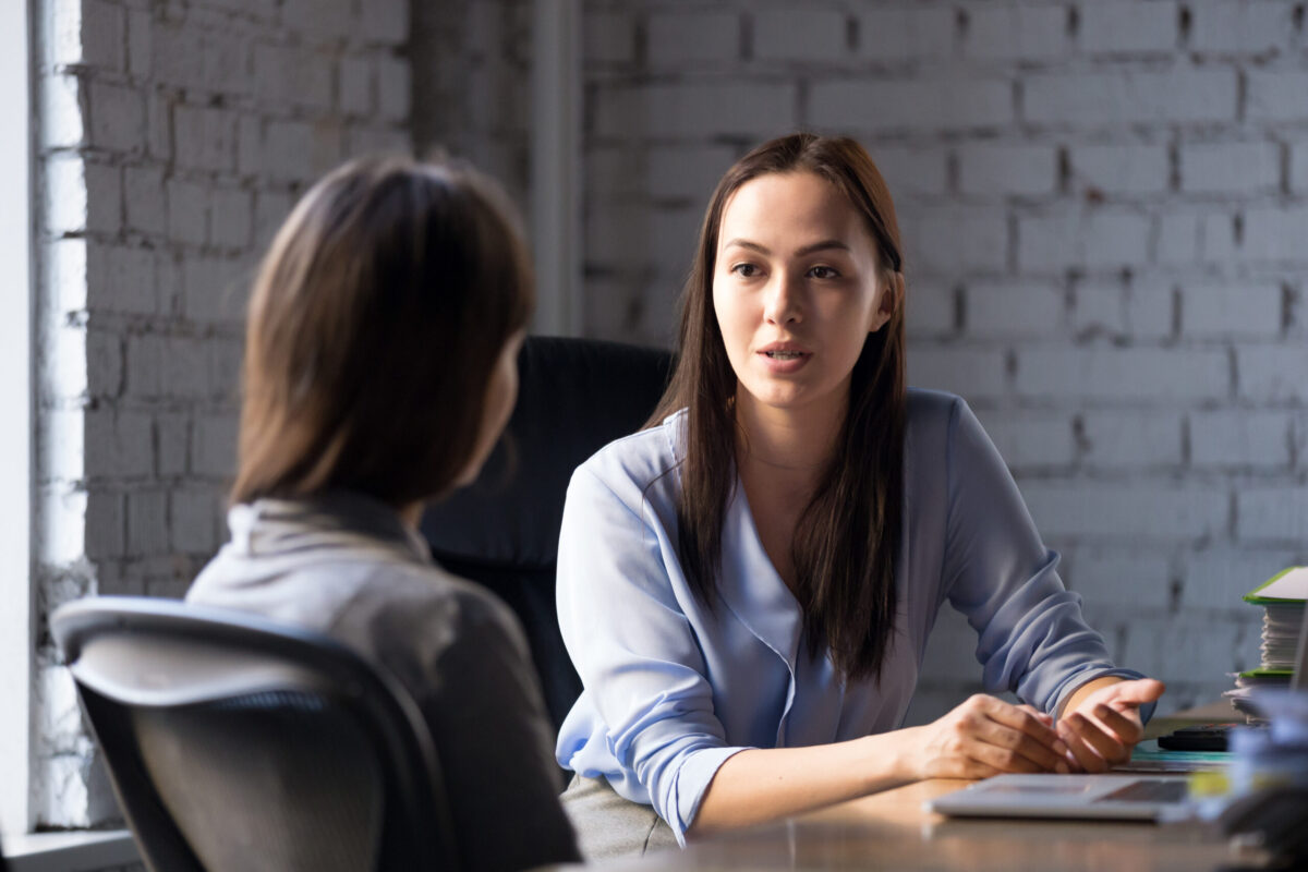 Two Female Professionals Having a Discussion at an Office Desk