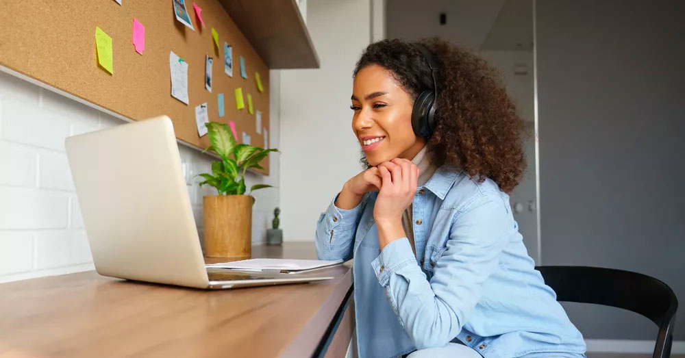 Woman wearing a headset chatting on a laptop