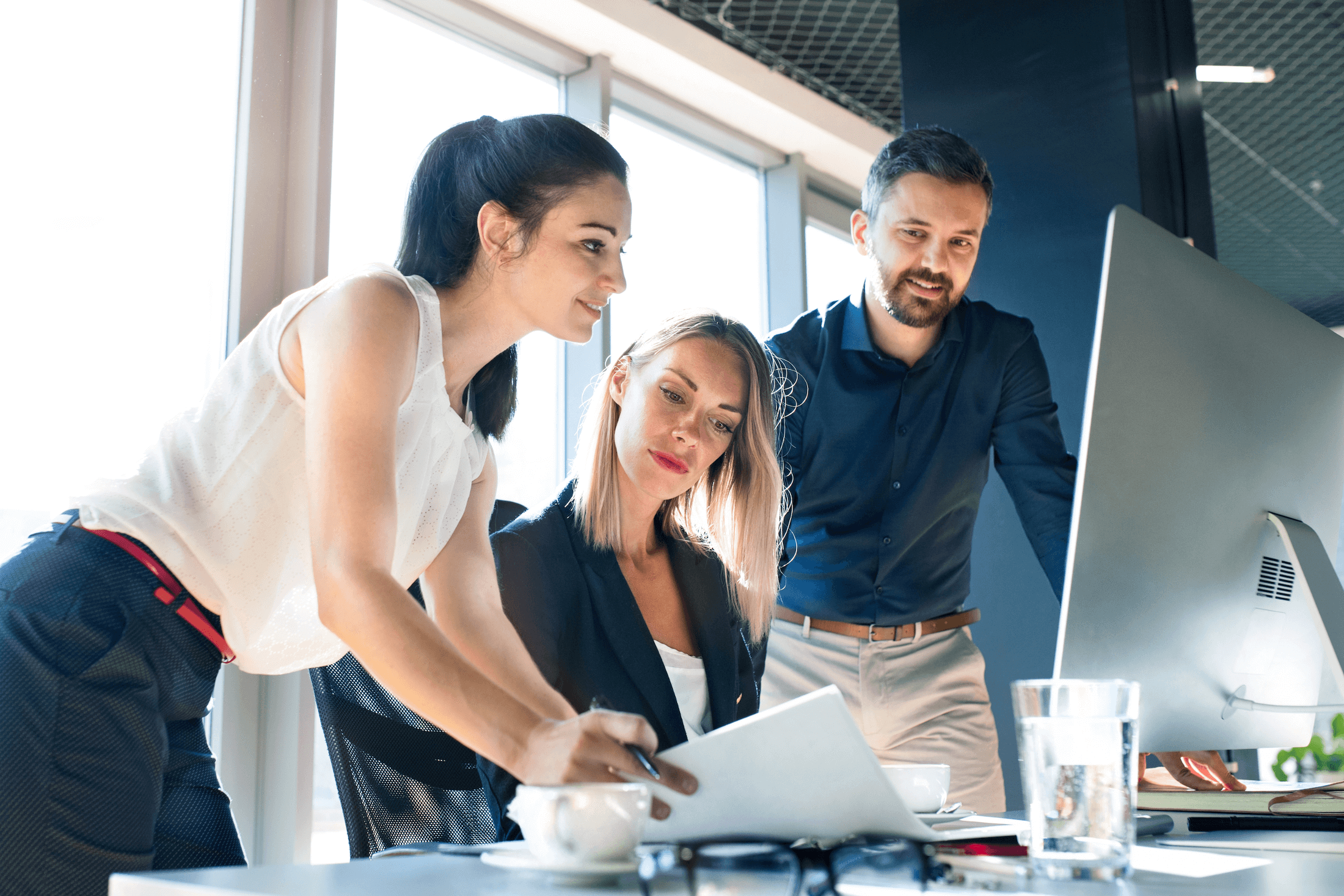 business leaders leaning over desk