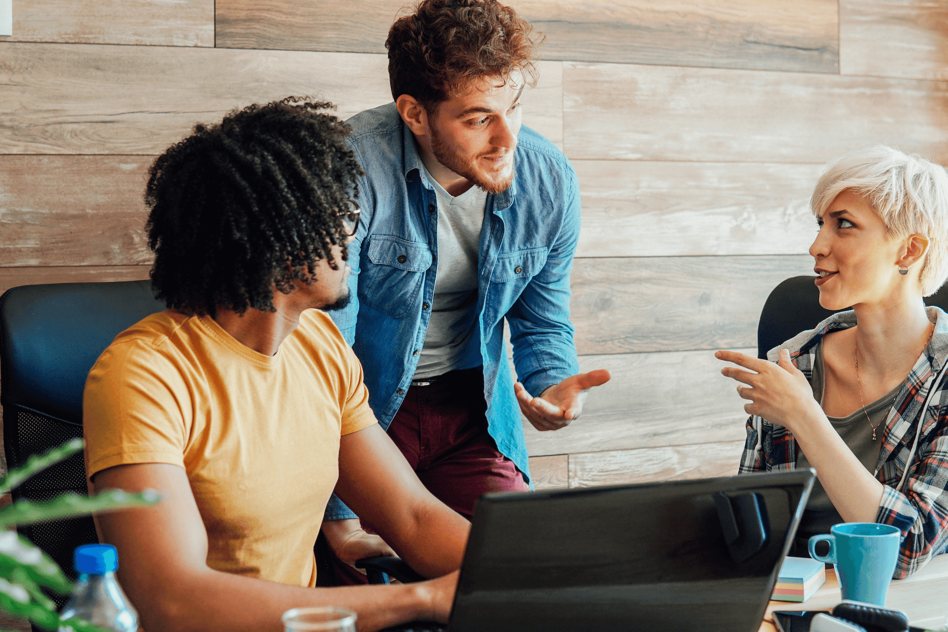 colleagues discuss work around desk